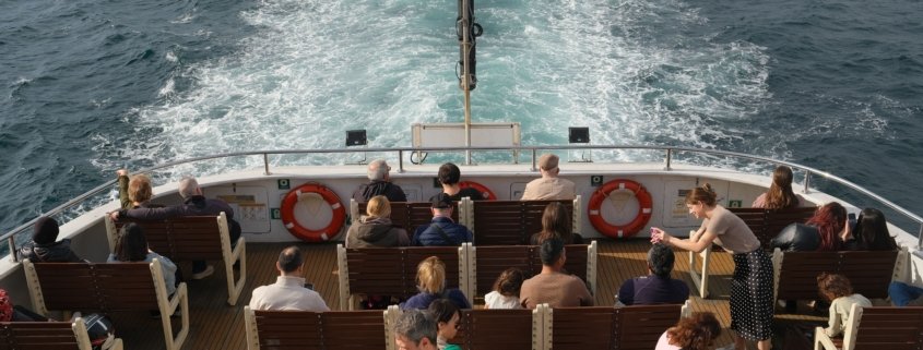 International guests watching the mangrove creeks from the open deck of a Tour De Sundarbans safari boat in the Sundarbans